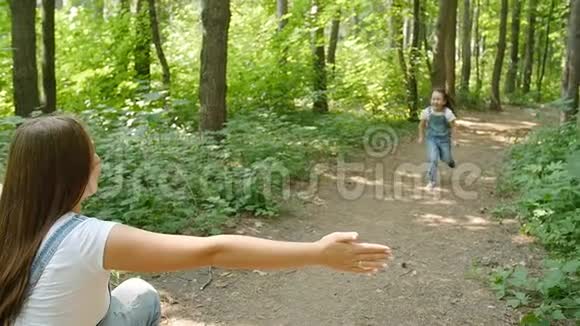 家庭观念可爱的女婴跑到妈妈的怀抱在公园里视频的预览图