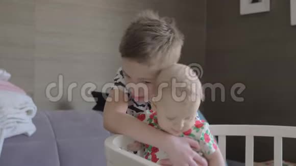 一个男孩抱着他的小妹妹在婴儿床上视频的预览图