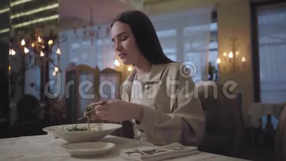 肖像年轻的女人长发吃什皮普斯普鲁恩斯坐在餐桌上在餐厅孤独的女士视频的预览图