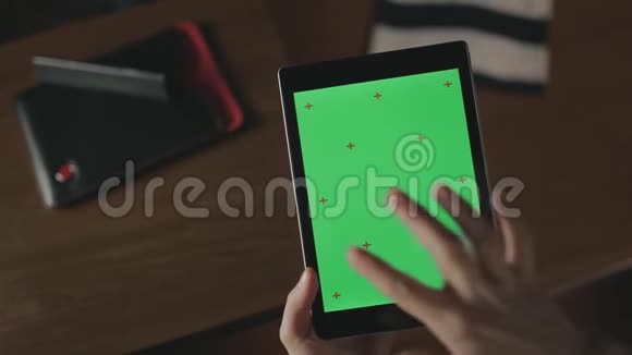 女性手持片关闭女士在平板电脑上刷绿色屏幕视频的预览图