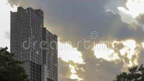 傍晚时分乌云密布在色彩斑斓的独特高层公寓4KUH的密集镜头后阳光显露视频的预览图