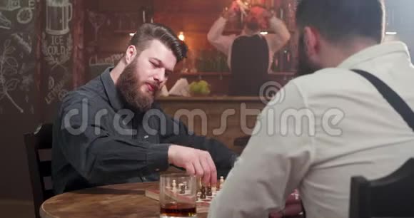 两个时髦的时髦男人在酒吧里下棋视频的预览图