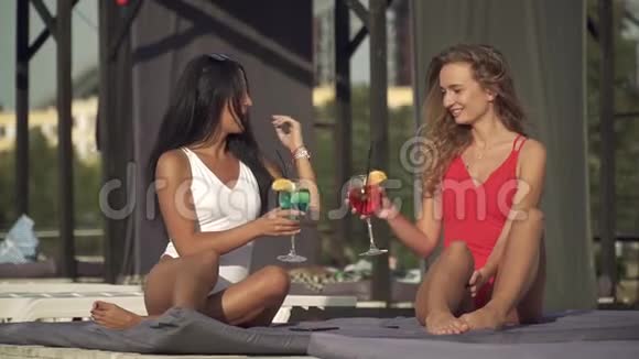 两个女朋友躺在躺椅上拿着新做的鸡尾酒视频的预览图