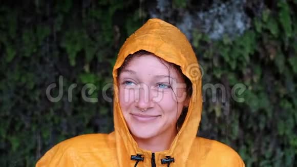 一个穿着黄色雨衣的蓝眼睛女孩抬起头闭上眼睛微笑着视频的预览图
