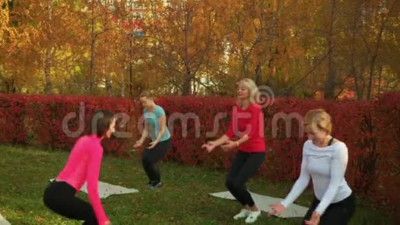 健身女性在秋季公园训练瑜伽锻炼团体瑜伽女子训练阿萨纳在城市公园体育界妇女视频的预览图