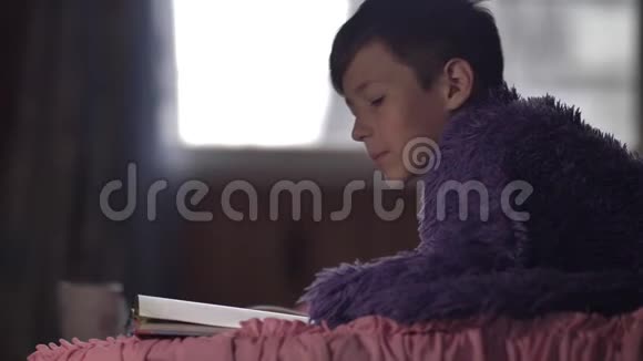 有趣的男孩在家拿着一杯热咖啡看书视频的预览图
