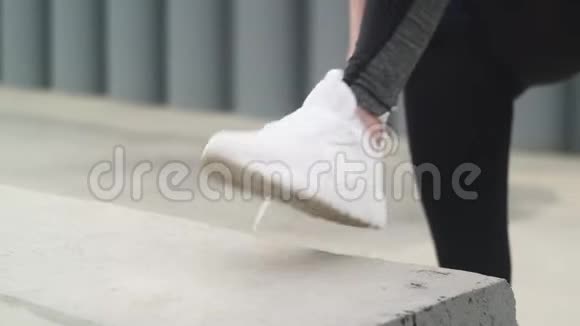 年轻的健身女子在公园里系运动鞋跑鞋带视频的预览图