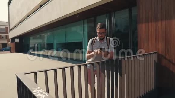 成年胡须男正在户外的智能手机屏幕上输入短信视频的预览图