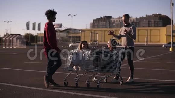 多种族的年轻人玩购物车站在购物中心附近的男性朋友视频的预览图