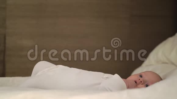 安静的婴儿手伸进嘴里躺在大床上视频的预览图