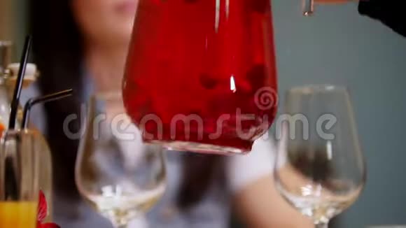 一对夫妇坐在一家咖啡馆的桌子旁一个人把饮料倒在玻璃杯里视频的预览图