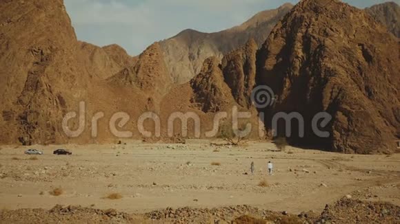 一群游客在炎热的沙漠中沿着岩石峡谷散步沙漠岩石背景埃及西奈慢动作全高清视频的预览图