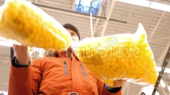 低角度射击的家伙拿着大黄玉米球包视频的预览图