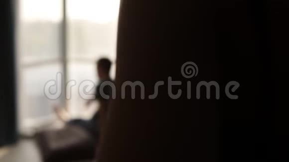 罕见的幸福白种人夫妇坐在窗前枕头和喝热茶年轻夫妇穿着睡衣视频的预览图