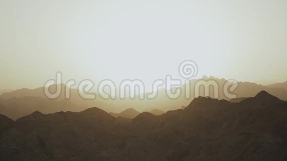埃及沙漠山脉令人惊叹的日落地平线下太阳的光芒照亮了天空视频的预览图