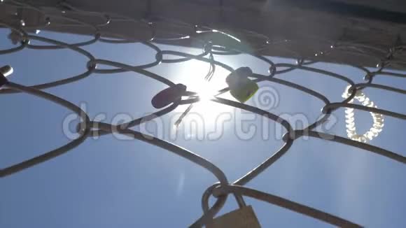 天空和太阳背景上铁网上的挂锁和丝带视频的预览图