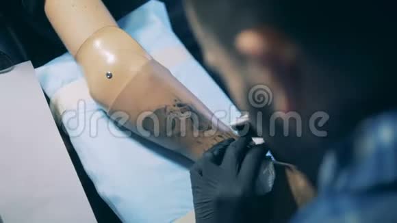 一只男性假肢上正在制作一个黑色墨水纹身视频的预览图