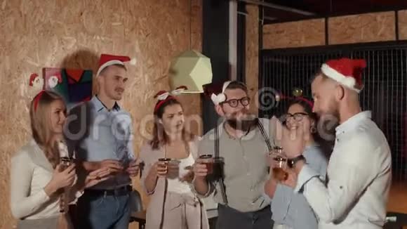 有胡子的男人在圣诞晚会上为朋友敬酒咯咯地笑着喝酒视频的预览图