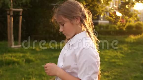 有着美丽头发的女孩在大自然的背景下阳光下害羞的少年视频的预览图