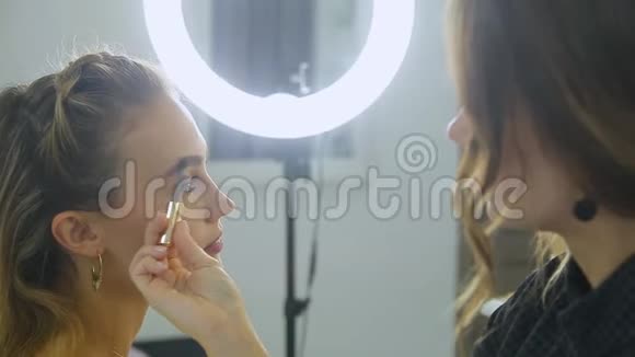 眉毛矫正美容师用刷子在顾客眉毛上涂油漆视频的预览图