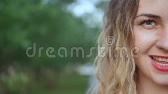 城市公园里绿树成荫的迷人年轻女子的半张脸一幅美丽的肖像特写视频的预览图