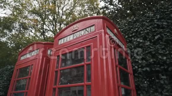 伦敦传统的红色电话亭在街上绿树掩映行动国家标志视频的预览图