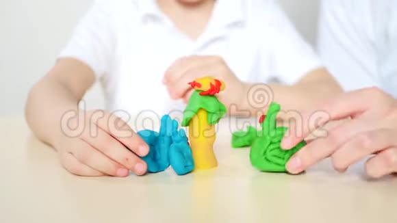 快乐的母亲和孩子一起玩塑料面团混合模型的图形视频的预览图