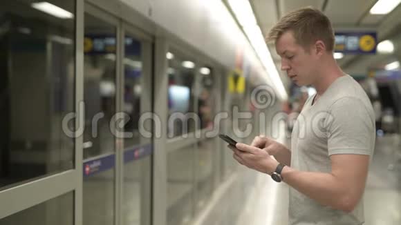 在曼谷等候火车时使用电话的青年游客简介视频的预览图