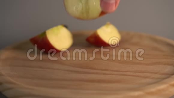 手把一个被咬了一半的红苹果放在木头表面视频的预览图