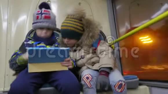 两个男孩在无轨电车上使用平板电脑视频的预览图
