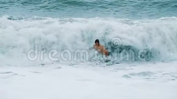 快乐有趣的人沐浴在海浪上的暴风雨中慢动作视频的预览图