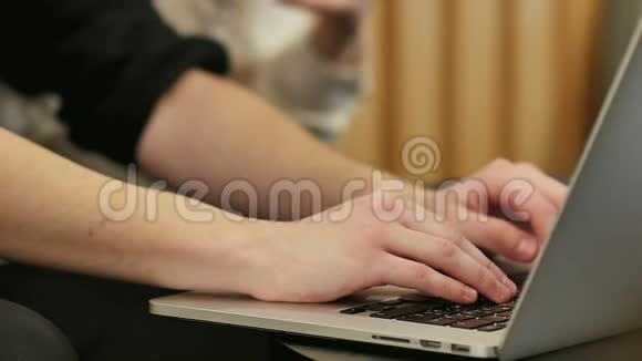 双手触摸笔记本电脑键盘上的打字视频的预览图