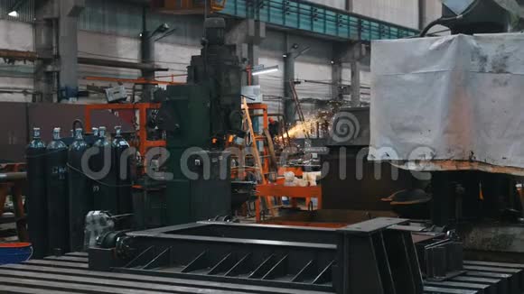工厂用于焊接和金属结构的气瓶在远处一个人在金属陶瓷上工作视频的预览图