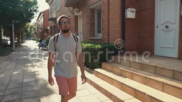 夏天早上放松的男性游客正在小城市散步视频的预览图
