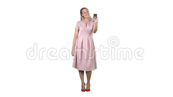 成熟女人穿着淡粉色连衣裙在白色背景上自拍视频的预览图