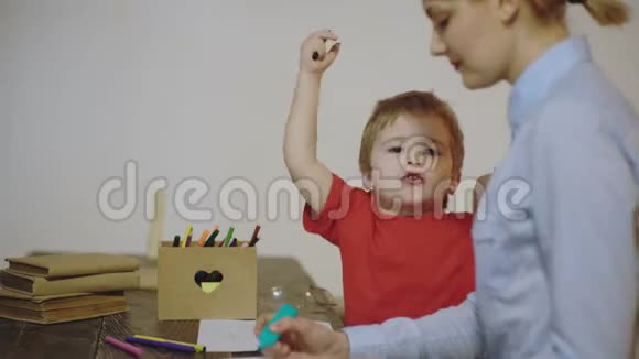 孩子和母亲用彩色铅笔画画带着母亲的男孩在白色背景上被隔离可爱的男孩视频的预览图