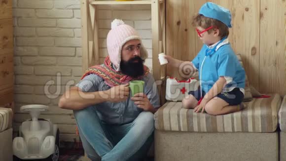 穿医生制服的男孩父子扮演医生父亲和儿子玩保健和治疗概念视频的预览图