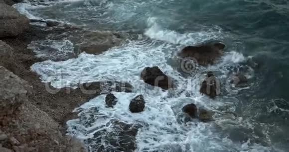海中的幻影蓝正拍打着岩石一个严酷的夜晚一片壮丽的海洋视频的预览图
