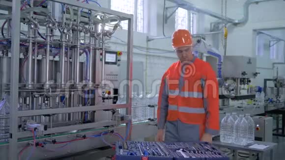 工厂服务技术人员在头盔和工作服修理工厂设备与特殊工具靠近输送线视频的预览图