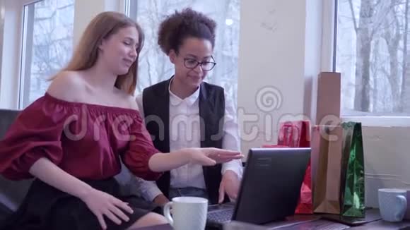 网上购物快乐的非裔美国女孩与朋友使用现代技术支付网上购物坐着视频的预览图