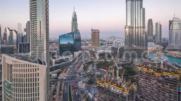 日落后迪拜市区的全景式天际线景观商场喷泉和摩天大楼在白天到夜间空中盘旋视频的预览图