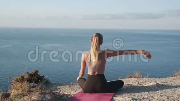 女性在垫子上练习瑜伽早晨冥想慢动作的背面视图视频的预览图