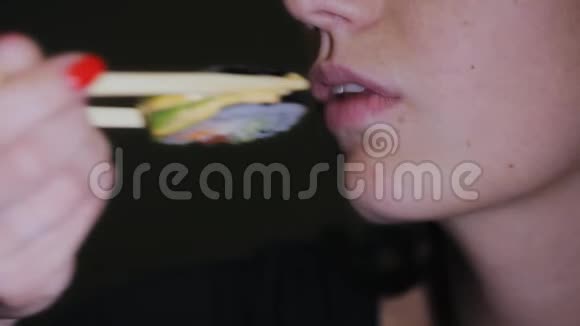 漂亮的年轻女人吃寿司筷子女人嘴吃寿司视频的预览图
