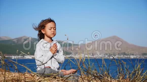 可爱的小孩咕噜独自坐在湖岸的莲花中视频的预览图