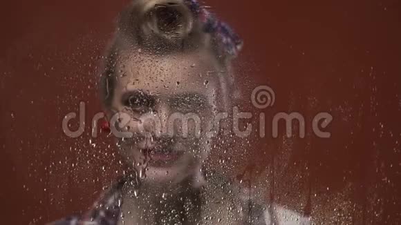 漂亮的金发女孩正在微笑在玻璃上喷洒一些水视频的预览图