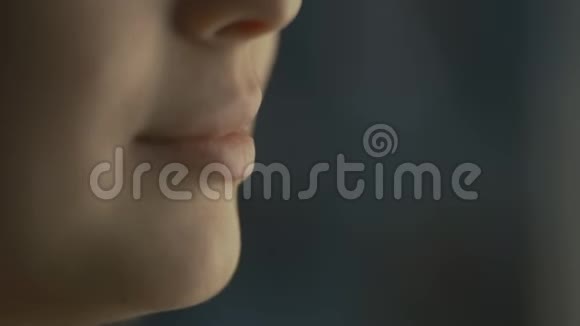 嘴唇年轻的女人在家里和一个朋友在窗户边说话脸上的一部分是一个女孩微笑闭上嘴视频的预览图