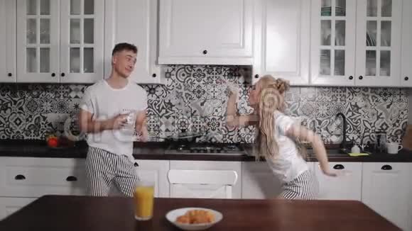 兴奋的年轻夫妇在厨房跳舞视频的预览图