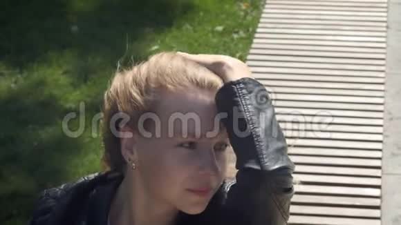 特写公园里穿着街服的年轻漂亮女孩在风中溶解棕色的长发剪头发的照片视频的预览图