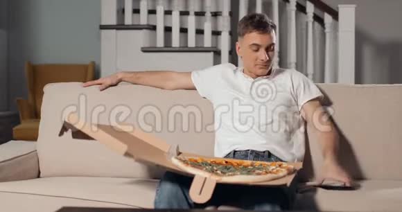 兴奋的男人看电视吃披萨视频的预览图