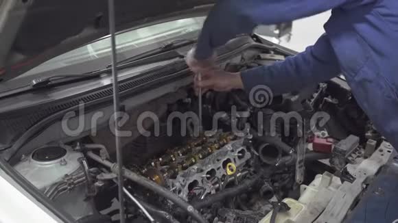 有经验的机械师在工具的帮助下旋转汽车机械师的发动机正在修理汽车以便视频的预览图